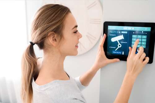 Woman granting entry to a visitor at her home using a sophisticated access control system.