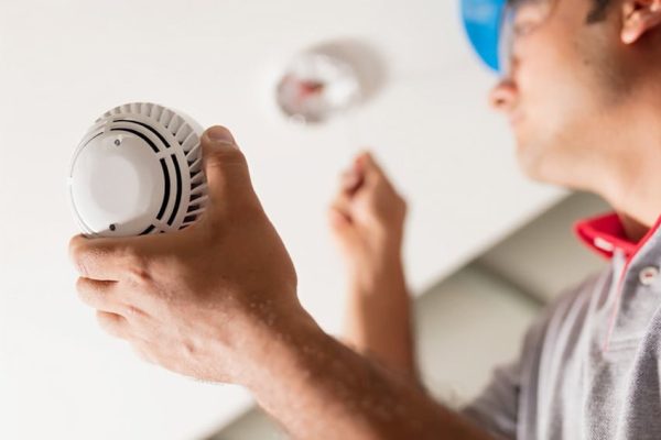 man installing smoke detector